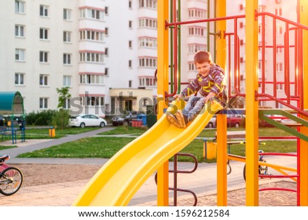 4 years old toddler boy playing at out door playground in Kindergarten school. Child development concept.