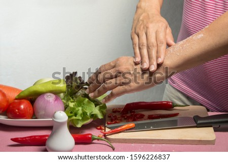 a housewife is rubbing her hand with salt and keep it on her skin for a period of time to reduce burning sensation