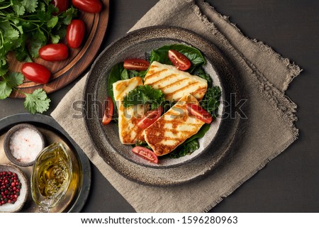 Cyprus fried halloumi cheese with healthy green salad and tomatoes. Lchf, pegan, fodmap, paleo, scd, keto, ketogenic diet. Balanced food, a greek clean eating recipe.