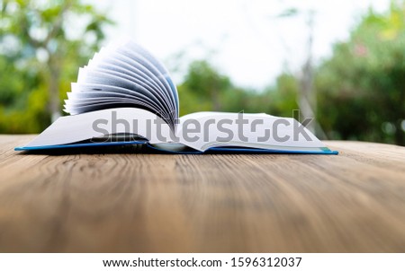 Open book on wooden table.