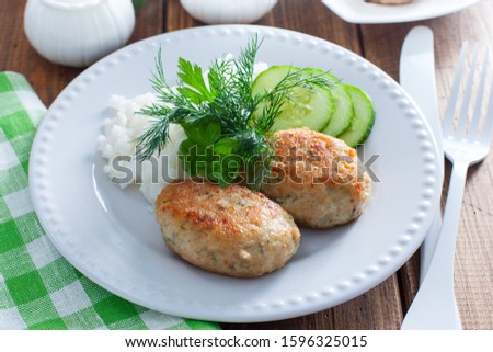 Fried fish cakes on a white plate with rice, horizontal