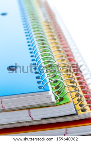 Multicolored spiral notebooks on a white background.