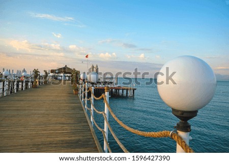 Empty wooden pier in the summer resort with festivity decoration