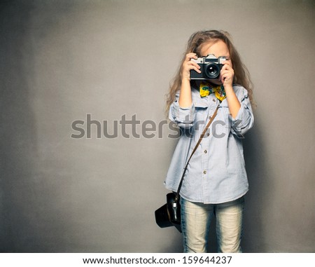 Child with camera. Little girl photographing
