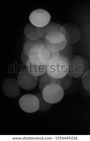 Abstract unfocused background - Black and white bokeh of different bubbles on a black background. Blurred pattern for backdrops.
