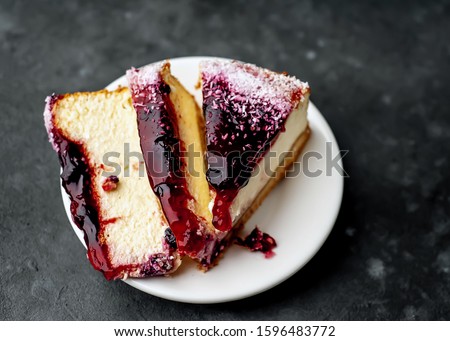 
Currant cheesecake on a white plate on a stone background, ready to eat