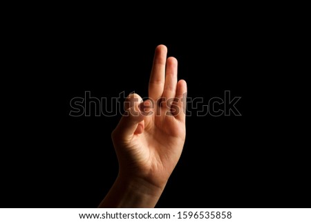 Hand Showing Sign of F Alphabet in American Sign Language (ASL), isolated on black background. Sign language