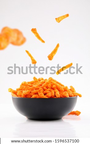 sparse stick corn chips in black bowl isolated on white background Royalty-Free Stock Photo #1596537100