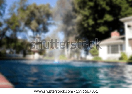 Abstract blur of pond and water fountain.