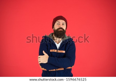 Warm and comfortable. Fashion menswear shop. Masculine clothes concept. Think and decide. Winter menswear. Man bearded warm jumper and hat red background. Winter season menswear. Personal stylist.