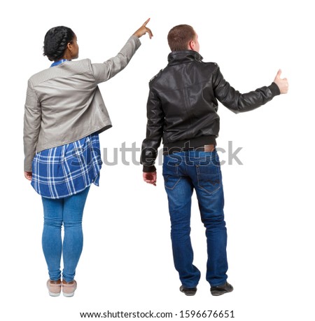 Back view of couple couple in winter jackets pointing. beautiful friendly girl and guy together. Rear view people collection. backside view of person. Isolated over white background.
