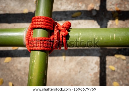 Blurred red rope knot on wood of scouts camp