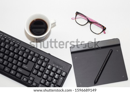 items for photo editing work, mouse, keyboard editing table, glasses and a cafe.