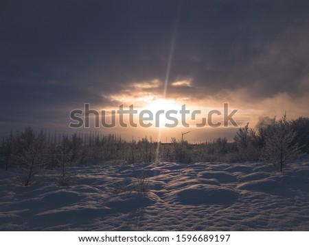 Sunset over snowy landscape. Cold winter.
