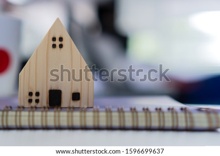 Mortgage loan and real estate property concept : Mortgage application form with black model wood house, pen on purchasers document for signature contact. Idea for refinance agreement for raise funds.