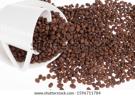 Roasted organic coffee beans - Coffea; photo on white background.