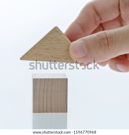 Man hand building house with toy blocks.