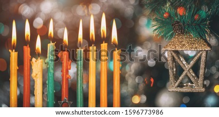 Nine burning color candles on colorful background with some decoration.