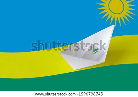 Rwanda flag depicted on paper origami ship closeup. Handmade arts concept