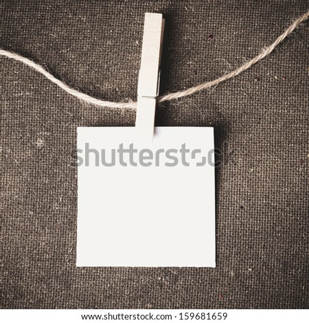 Close up of a note and a clothes peg on grunge cloth background with clipping path