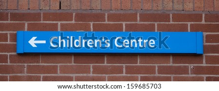 children's centre direction sign on brick wall