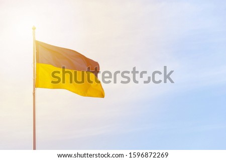 Blue yellow flag of Ukraine against the sky. Fabric develops in the wind.