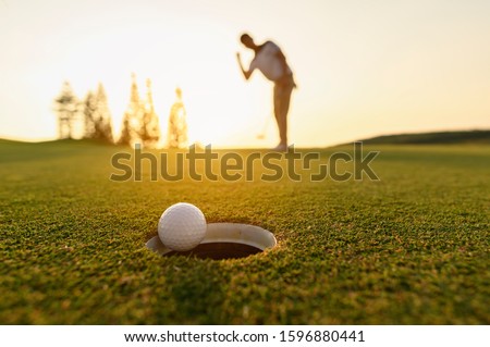 lifestyle, golf, activity, outdoor, sport, golfer concept. Golf balls that are going to be hole by golfers at the green grass golf course at sunset.