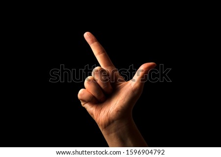 Hand Showing Sign of L Alphabet in American Sign Language (ASL), isolated on black background. Sign language