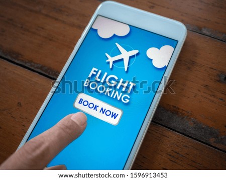 Flight booking online with smartphone. Close-up finger touching on mobile phone for buying or booking air flight online airline ticket.