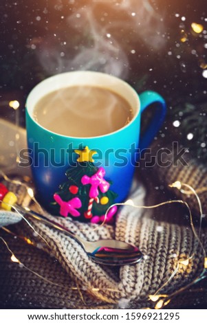 A Cup of hot cocoa in a Christmas mug on the background of Christmas garlands. Merry Christmas and happy New year. Selective focus.