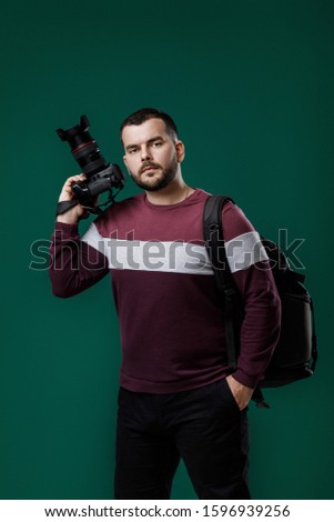bearded man photographer takes images with professional digital photo camera