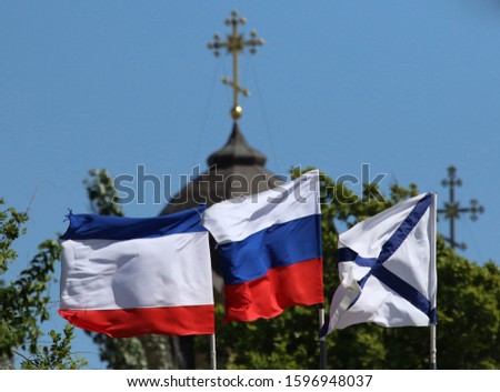 Flag of the Republic of Crimea, Flag of the Russian Federation, St. Andrew's flag and the cross of an Orthodox church in the city of Yevpatoriya (Crimea, Crimean peninsula).