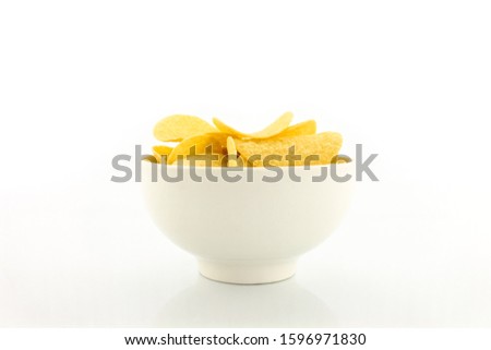 potato chips on bowl on yellow background. Royalty-Free Stock Photo #1596971830
