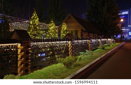 Evening in the park. Summer cafe with a beautiful New Year lights on a dark sky background.