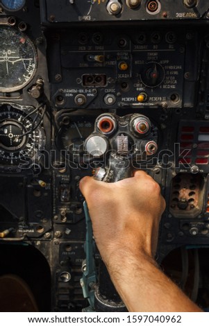 Pilot's hand on the military aircraft control knob. In the cockpit of an old, Soviet military jet. Close-up. Text translation from Russian "pitching nose up" Royalty-Free Stock Photo #1597040962