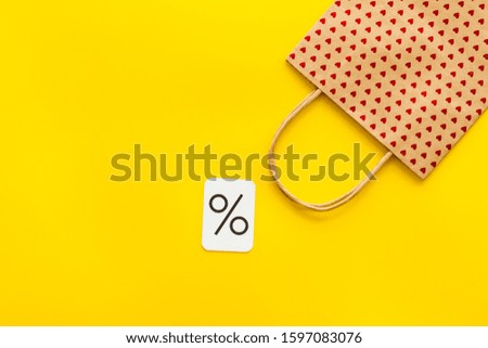 Shopping concept. Paper bag on yellow background top-down copy space