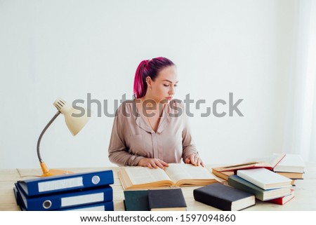 beautiful business woman working in an Office behind a table with books