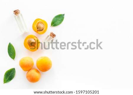 Fruit aroma oil. Apricot kernel oil on white background top view frame copy space Royalty-Free Stock Photo #1597105201
