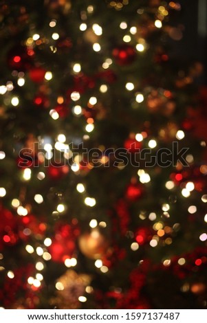 Blurred defocused picture of Christmas tree golden lights in the night, festive background for design