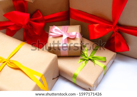 Boxes with gifts on a light, blue background and under the Christmas tree. Gift in the hand. Christmas presents, Nicholas Day, Valentine's Day. Bright boxes with bright ribbons. Gifts in Macro