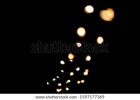 a lot of abstract golden bokeh of different shapes, degree of blur similar to sparks on a black background. no focus