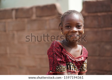 Smiling African Girl With a Wet Face After Having Taken A Sip From The Water Borehole Royalty-Free Stock Photo #1597194361