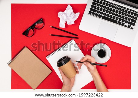 School and office supplies lie neatly on a red background