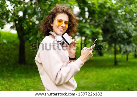 attractive european girl with phone and credit card with mockup on green park background