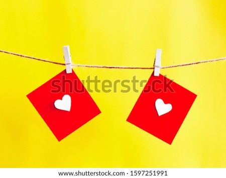 
Red hearts set on string on a yellow background. Valentine's concept. Space for text