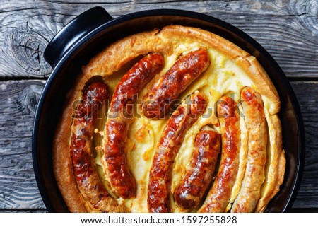 Toad in the hole, Sausage Toad, traditional English dish consisting of sausages in Yorkshire pudding batter, horizontal view from above, flatlay, close-up
