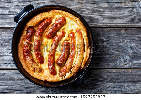 Toad in the hole, Sausage Toad, traditional English dish consisting of sausages in Yorkshire pudding batter, horizontal view from above, flatlay