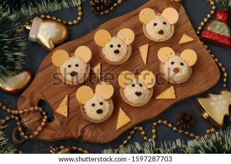Tartlets Mice with cheese fo the New Year 2020 on wooden board on dark background, horizontal orientation, Closeup
