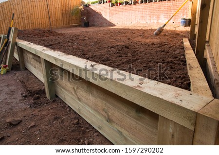 Garden Wooden Sleeper Retaining wall  Royalty-Free Stock Photo #1597290202