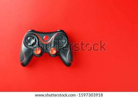 Game controller controller on red background. Device to control and control the game. Royalty-Free Stock Photo #1597303918